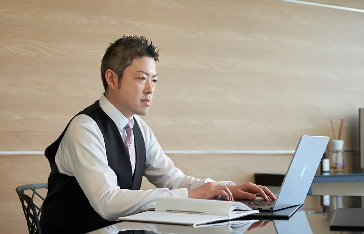 男性がPCを使用して仕事をしている様子。