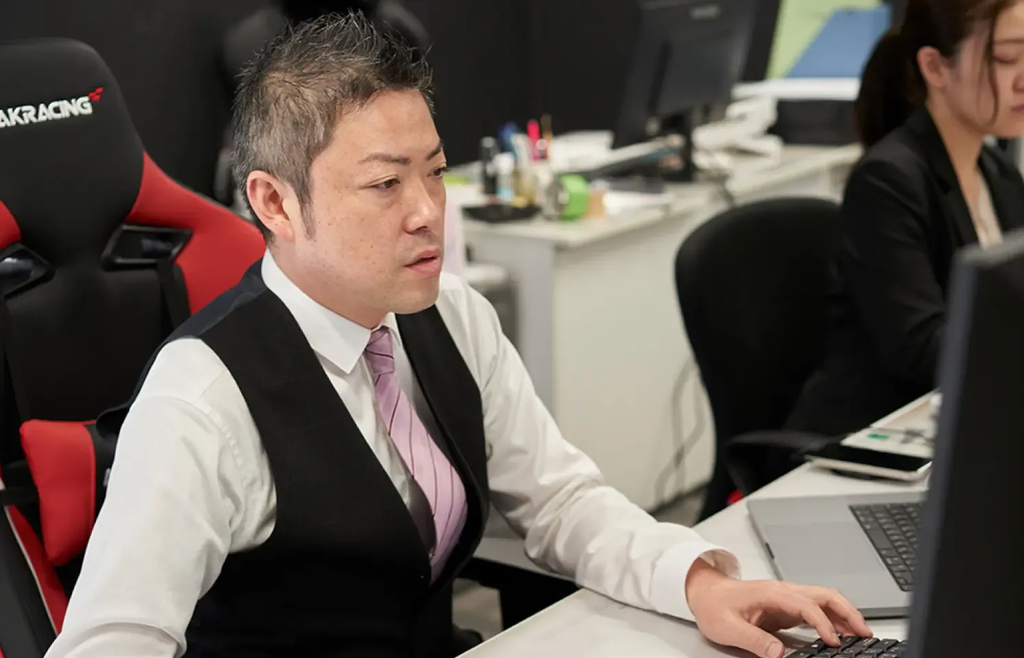 男性がPCを使用して仕事をしている様子。