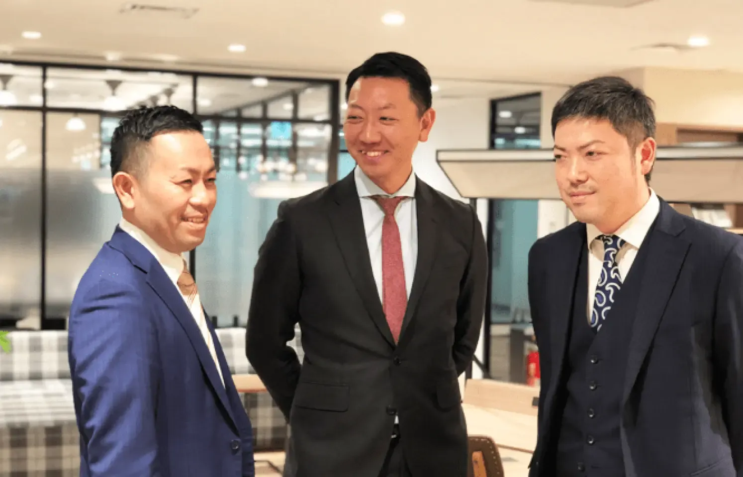男性3人が室内で歓談している様子。